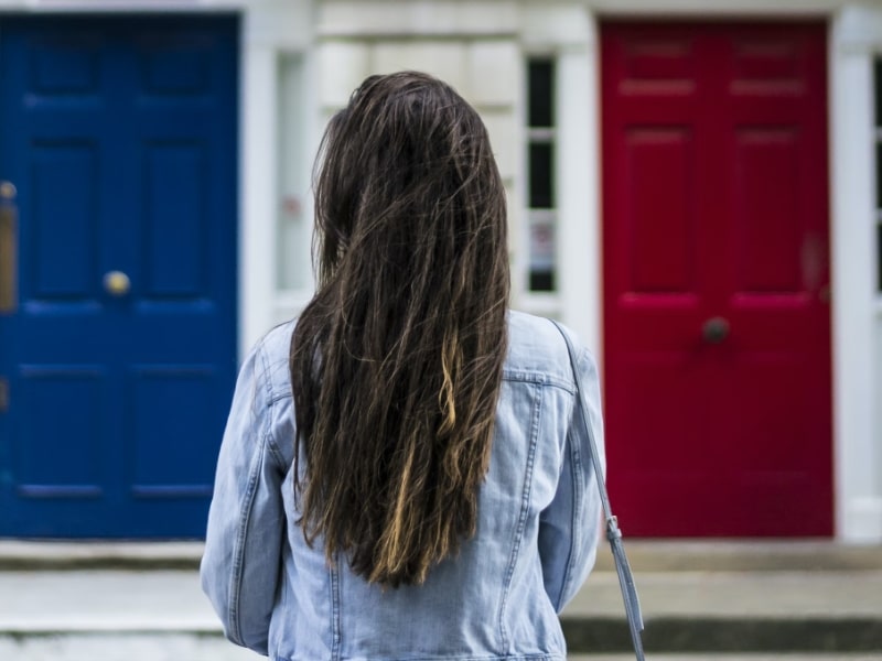 woman standing before doors red blue